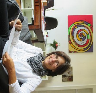 Superintendentin Angelika Zädow in ihrem Büro, sie lächelt und ist fröhlich, im Hintergrund das bunte Bild einer Spirale, Foto: SGP